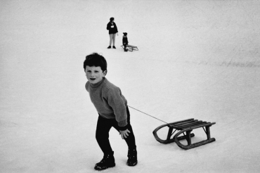 Enfant remontant la pente avec sa luge